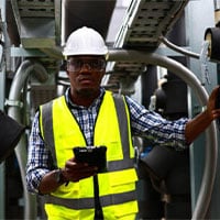 man in reflective jacket and hard hat next to machine 400x300 1